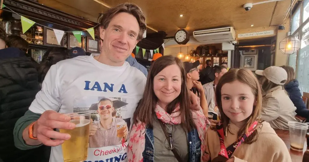 Ian following the London Marathon in a pub with Russell's wife and daughter as they celebrate his success
