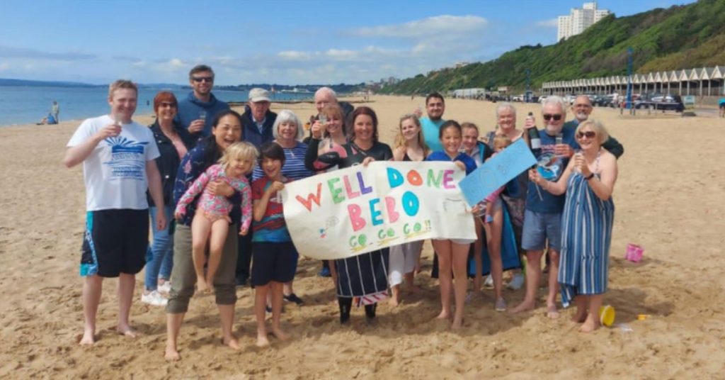 Swimmer Katherine with friends and family on the beach
