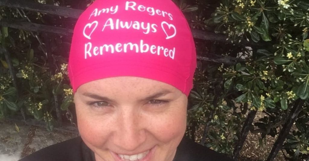 Katherine in a swim cap that reads 'Amy Rogers, always remembered.'