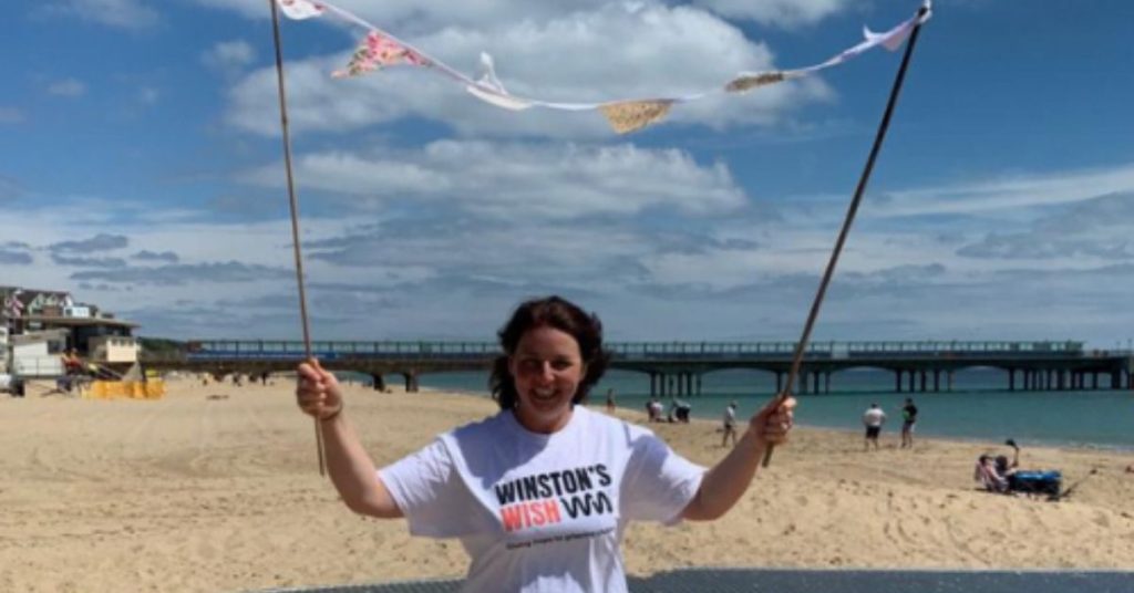 Katherine on the beach celebrating after finishing her 40 day swim challenge