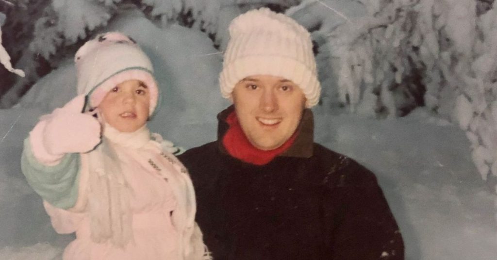 Sophie and her dad in the snow as a young child