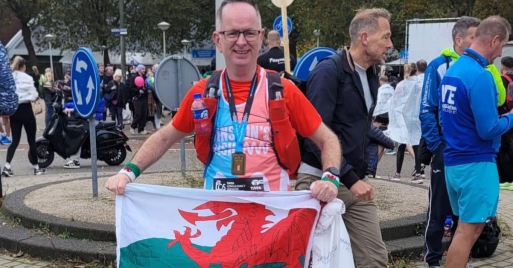 Ian at the Amsterdam Marathon holding a Welsh flag