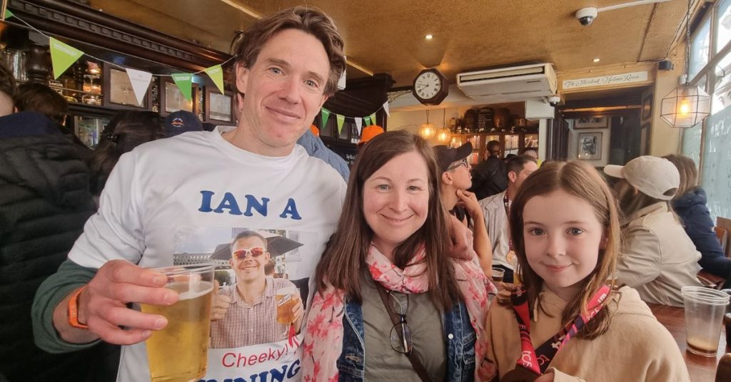 Ian following the London Marathon in a pub with Russell's wife and daughter as they celebrate his success
